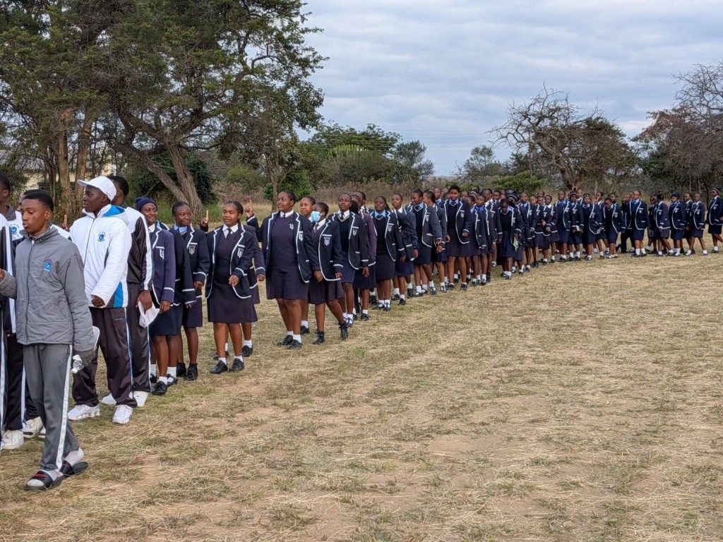 Usher students lined up in school uniform on the sports field